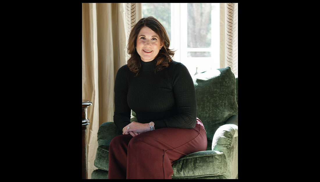 Rachel Moore sits on a chair, smiling