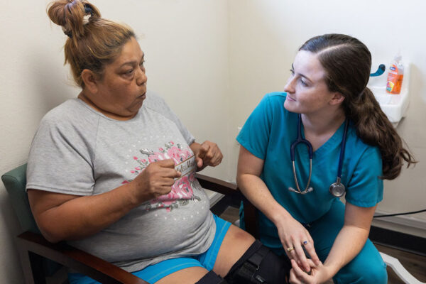 Physician Talks With A Patient In A Small Clinic Room