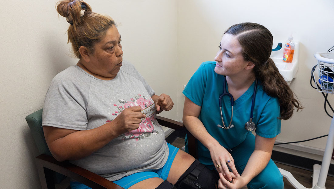 Physician talks with a patient in a small clinic room