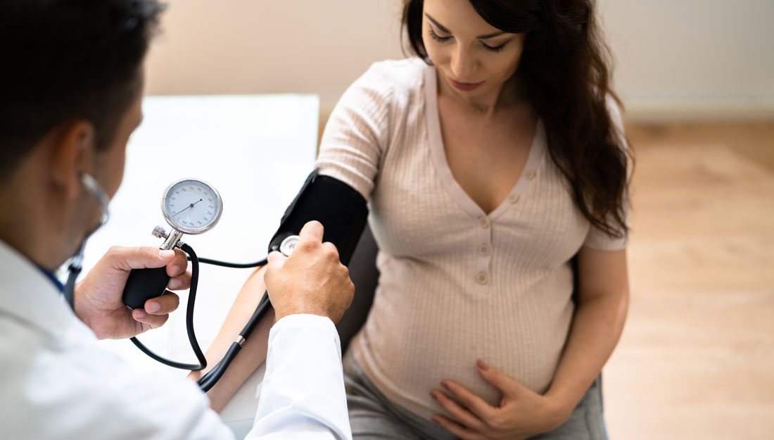 Doctor Measuring Blood Pressure Of Pregnant Woman