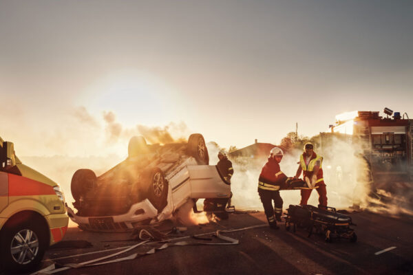 Paramedics And Firefighters Rescue Person From A Vehicle Crashed Upside Down On A Road